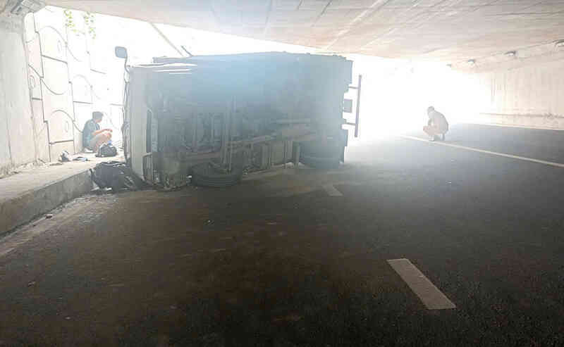 Ô tô tải biển xanh lật đè 2 xe máy ở của ngõ TPHCM, hai người bị thương